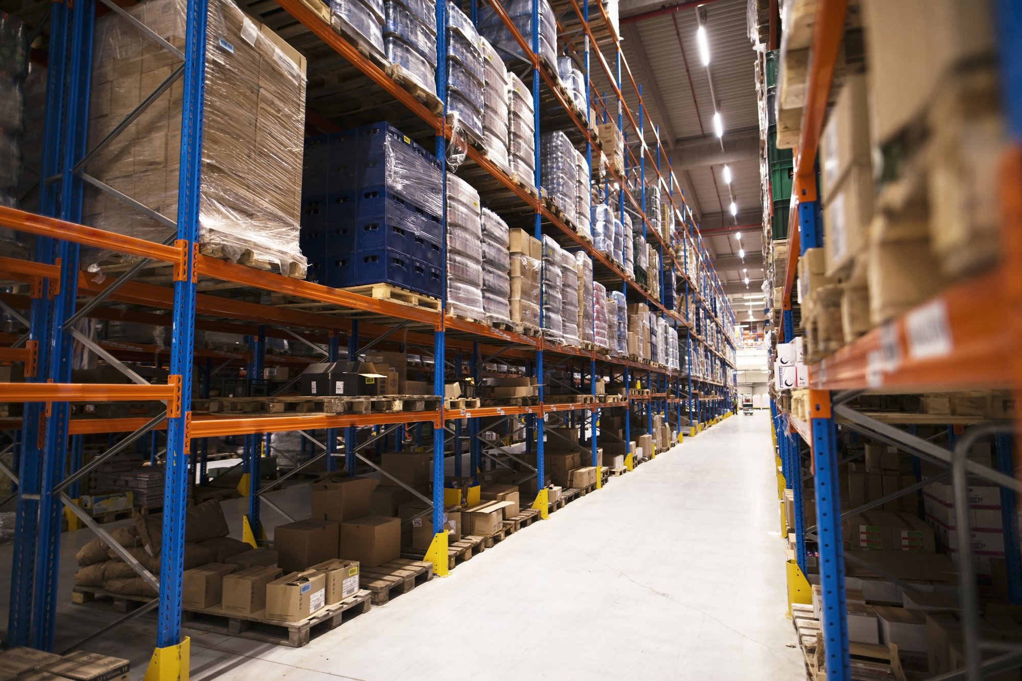 interior-large-distribution-warehouse-with-shelves-stacked-with-palettes-goods-ready-market (1)